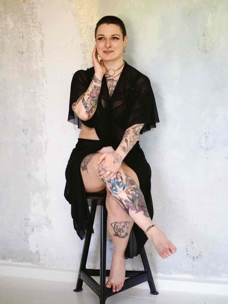 Boudoir Shooting Berlin – privates Studio mit Sofa, Tattoos und rohen Wänden.