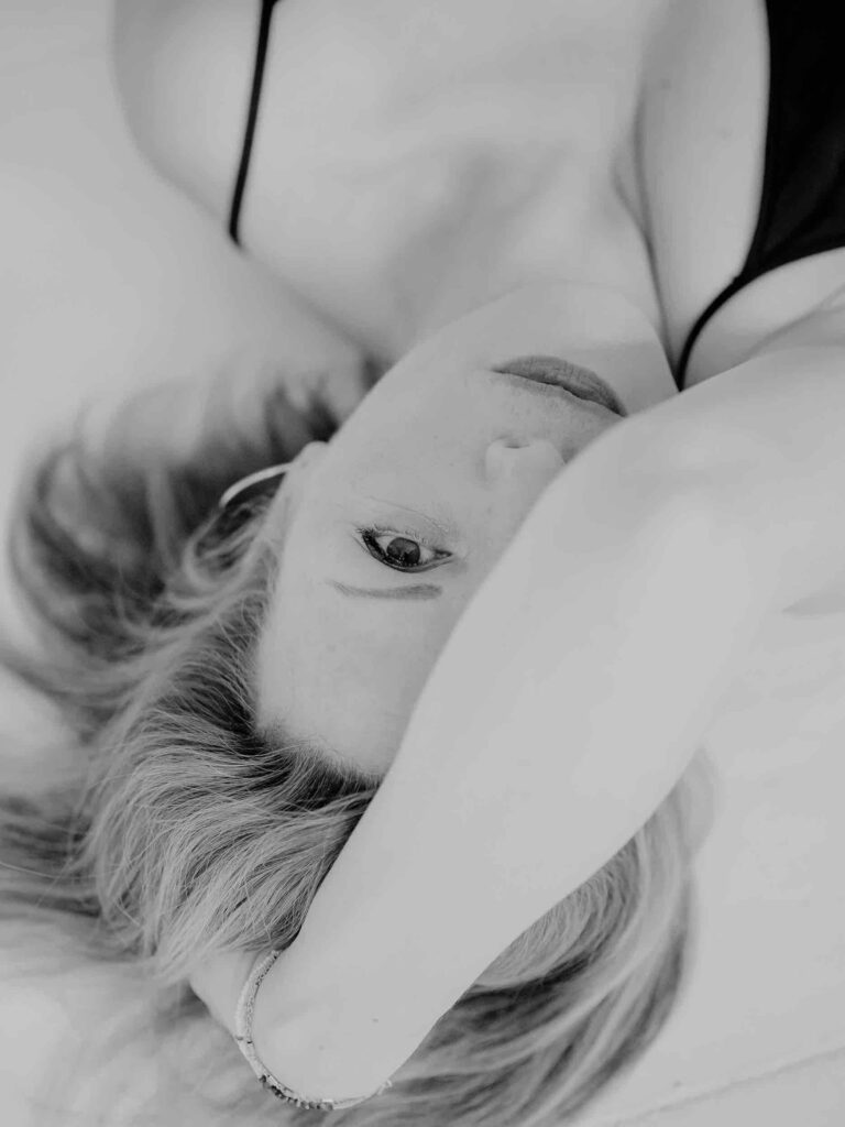 Boudoir Foto: schwarz-weiße Portrait-Aufnahme einer Frau im Liegen